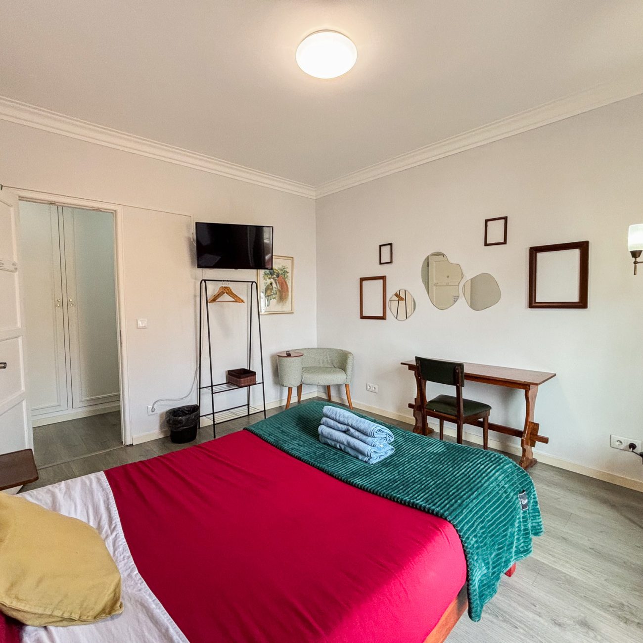 white room with artistic deco and wooden furniture and double bed